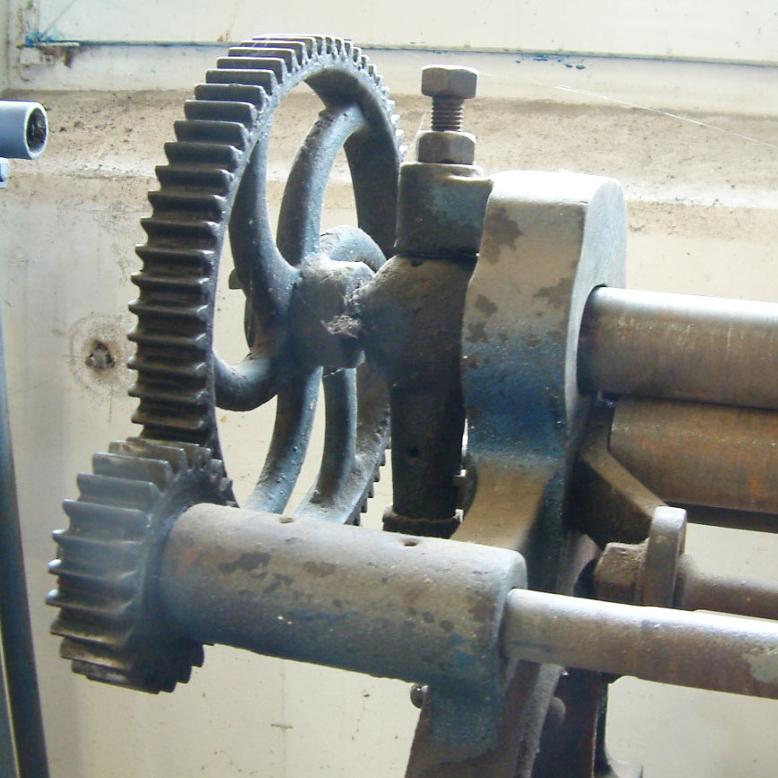 Werkstattdetail: Walzen und Zahnrad einer Metallbearbeitungsmaschine