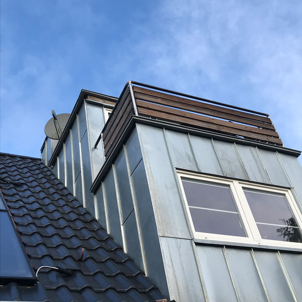 Metallverkleidung einer Dachgaube unter blauem Himmel